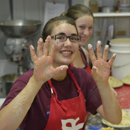 Les mains dans la pâtes des tartes aux pommes
